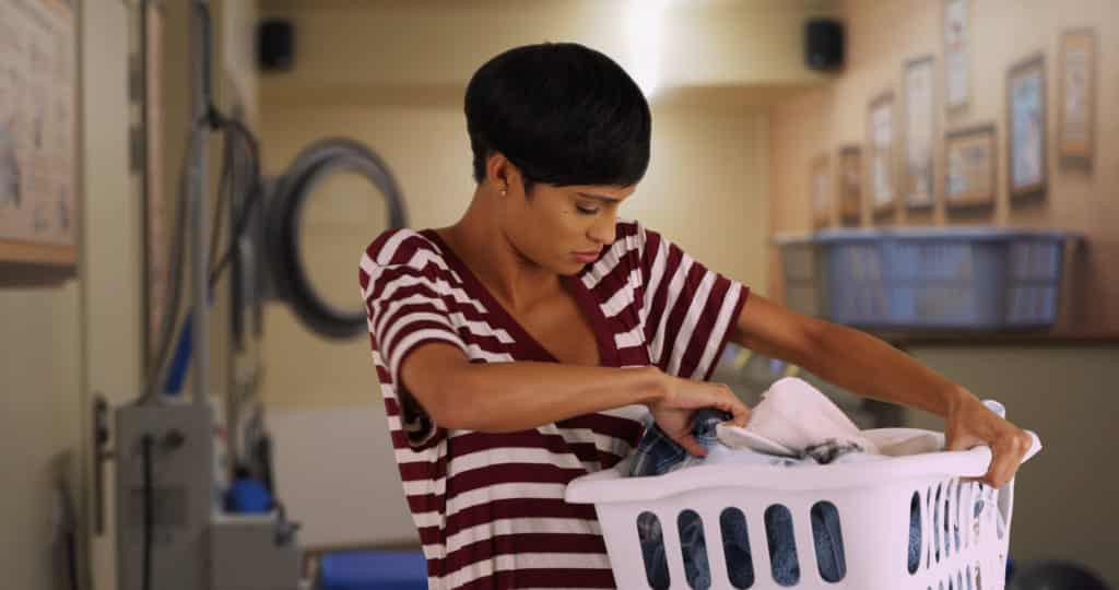 Portrait of young mom doing laundry at laundromat Versatile Vinegar